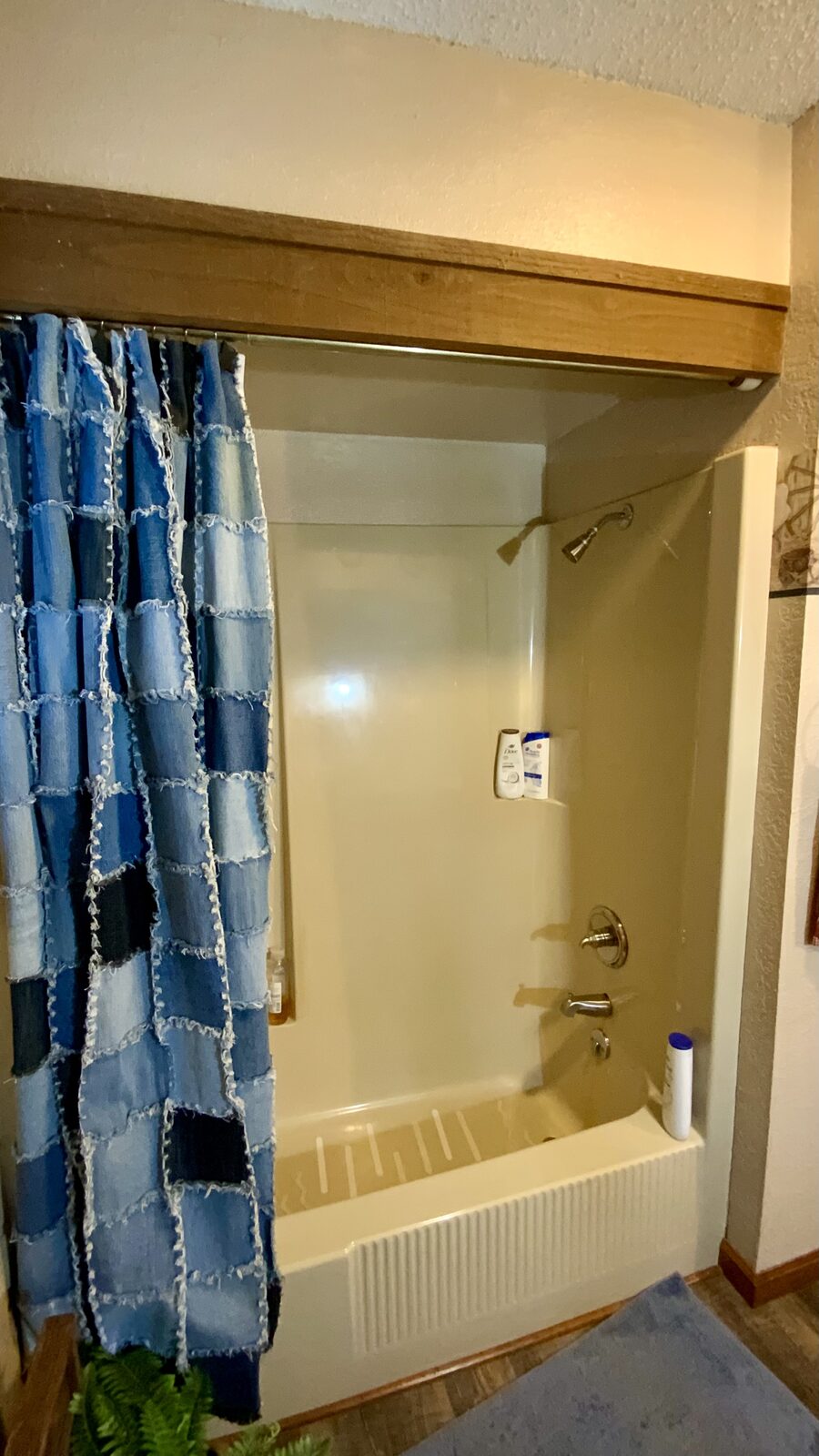 Dated almond colored tub and shower surround before a Miller Builds shower replacement