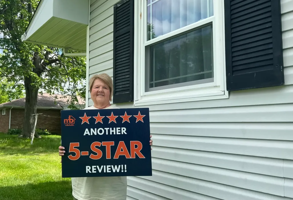 Miller Builds customer holding an Another 5-Star Review sign beside her newly installed replacement window