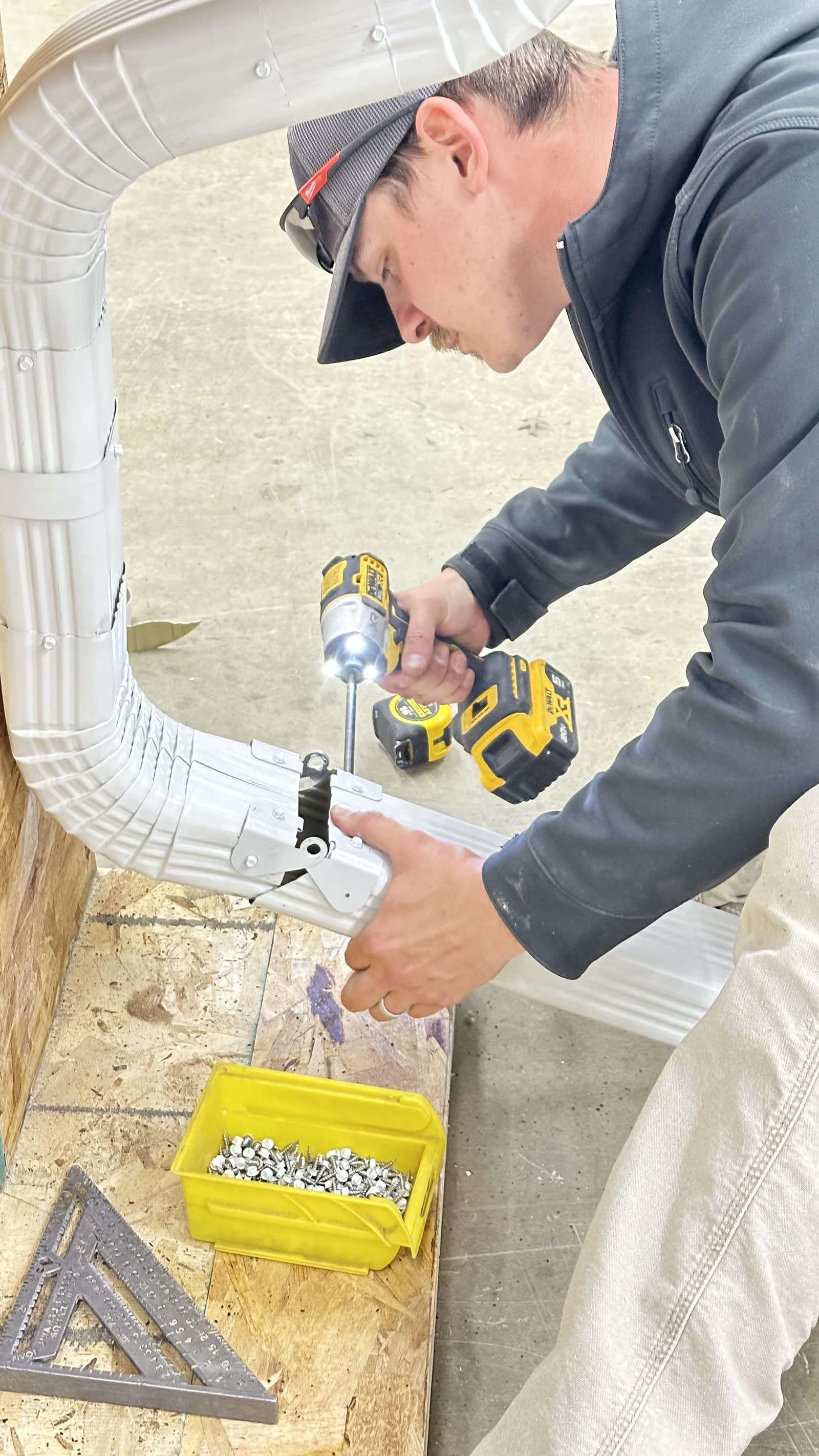 Miller Builds crew member fabricating a custom downspout elbow on site